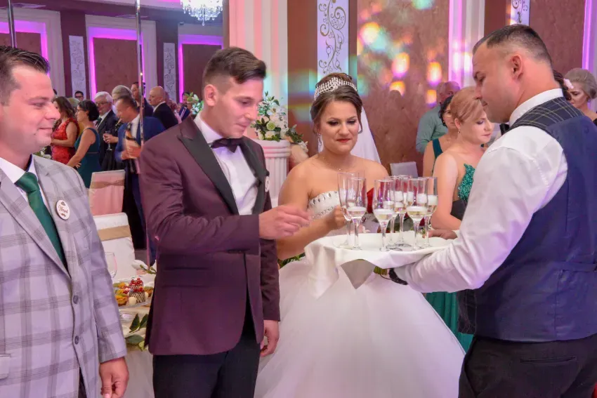 Invitados con atuendo formal sosteniendo copas de champán en una recepción de boda.