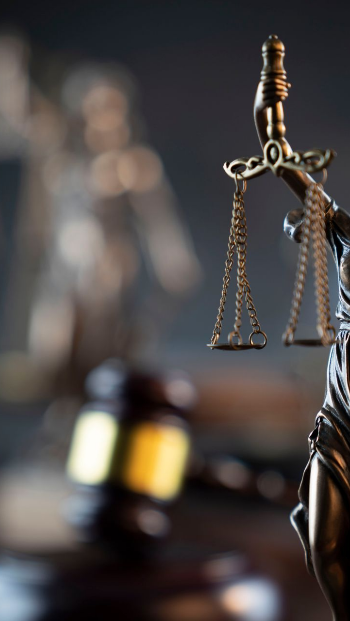 Balance de la justice, maillet et statue de la Justice dans un cabinet d'avocats.