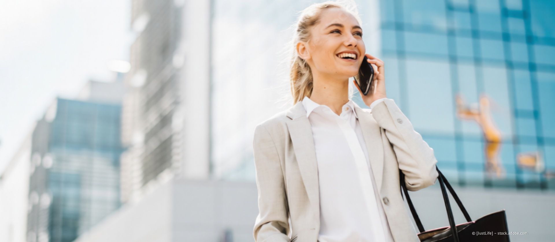 Personen und ein Immobilienmakler sitzen an einem Tisch mit einem Musterhaus und Dokumenten.