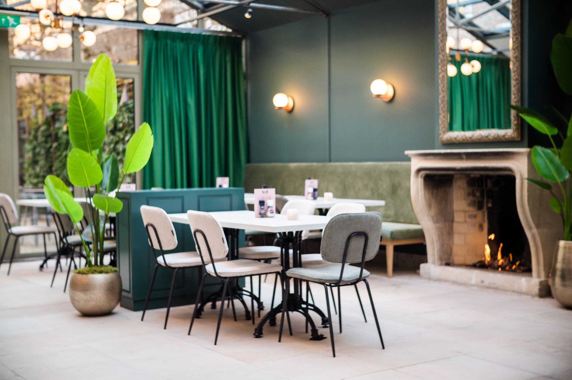 Een restaurant vol tafels, stoelen en glazen wijn.