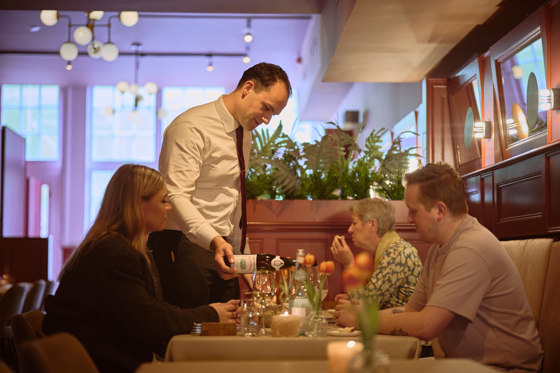 Een groep mensen zit aan tafels in een restaurant.