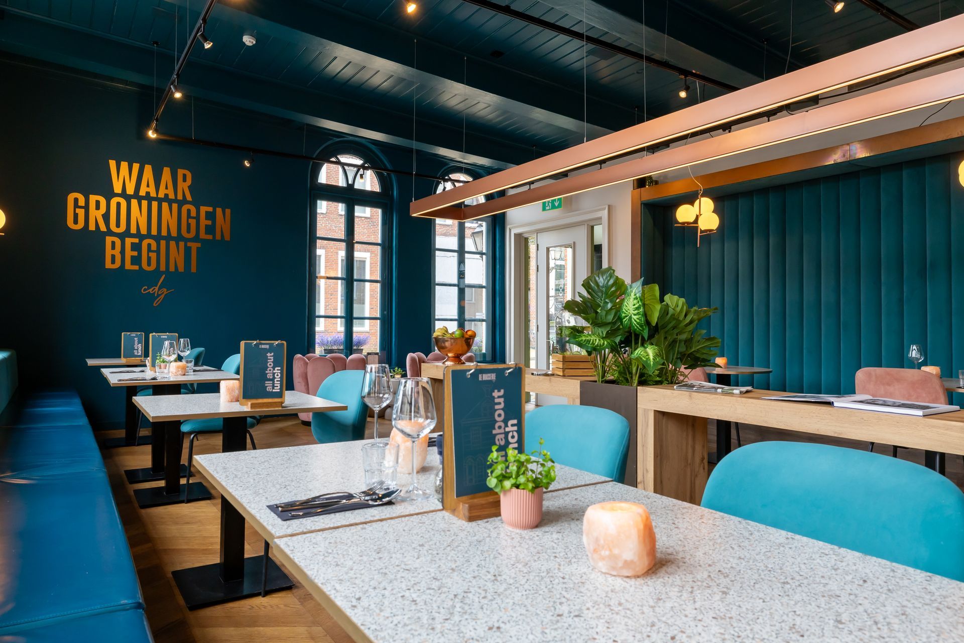 Er zijn veel tafels en stoelen in het restaurant.