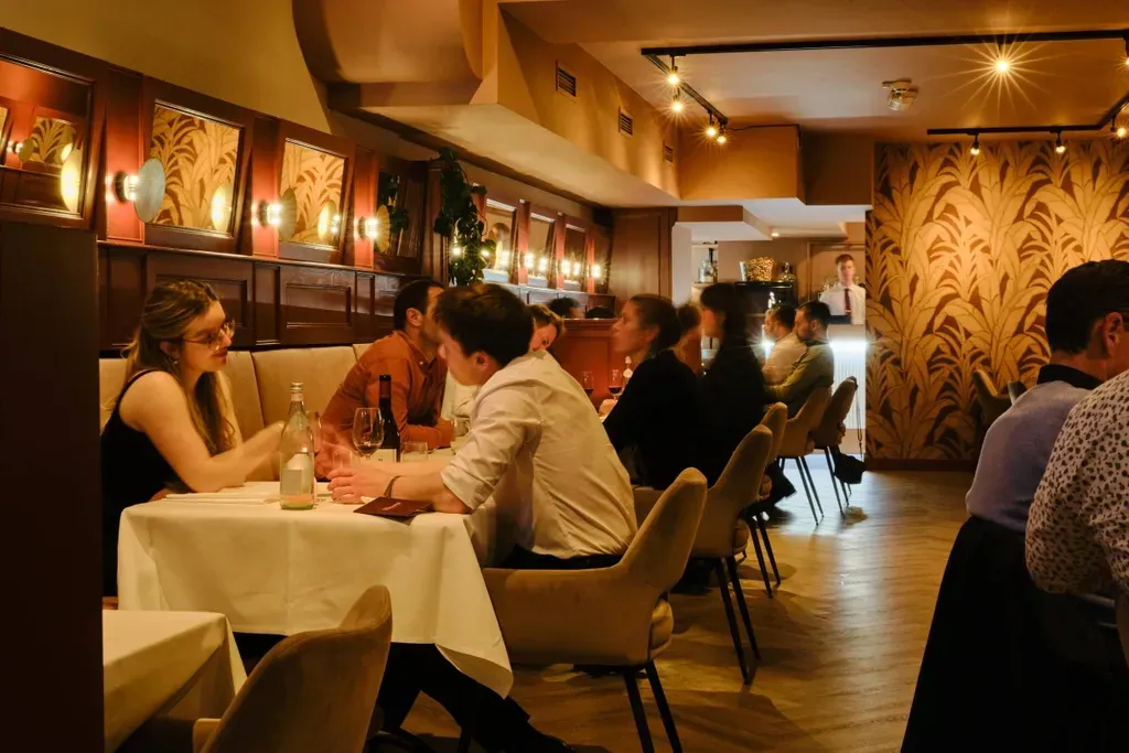 Een groep mensen zit aan tafels in een restaurant.