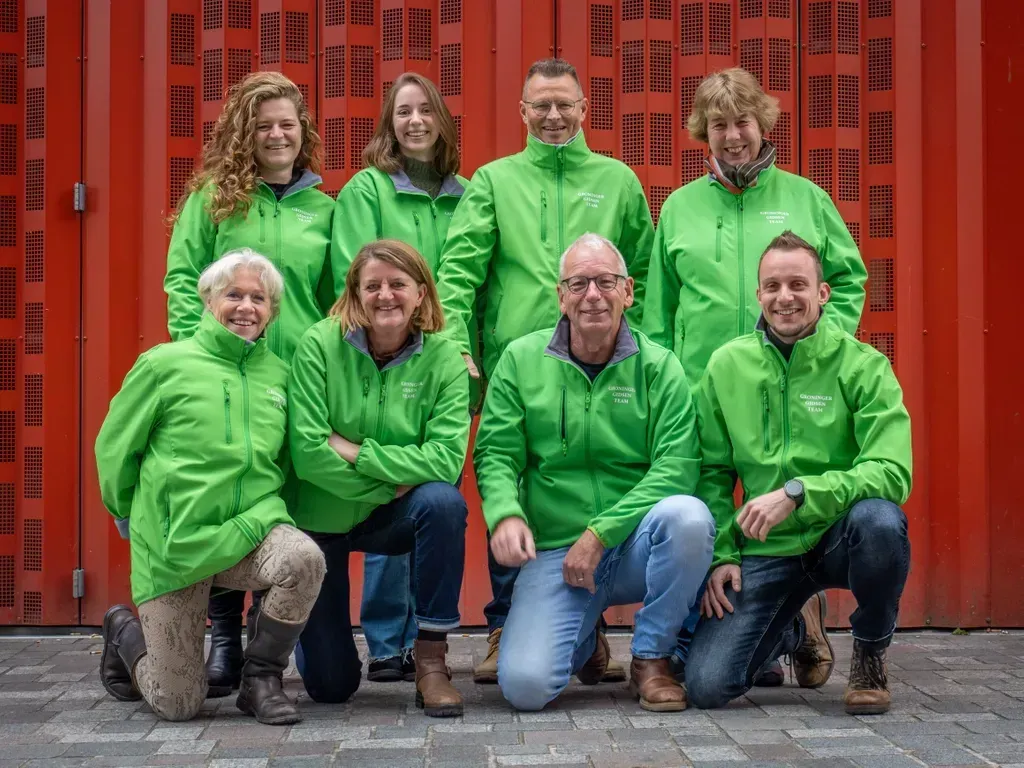 Gebouw van rode baksteen met boogramen, vlag en uitzicht op straat onder een bewolkte hemel.