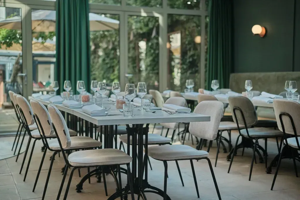 Een restaurant vol tafels, stoelen en glazen wijn.
