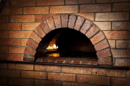 Christian Düssel Ofen- und Cheminéebau – Steinofen aus Backsteinen im Stil eines traditionellen Pizzaofens
