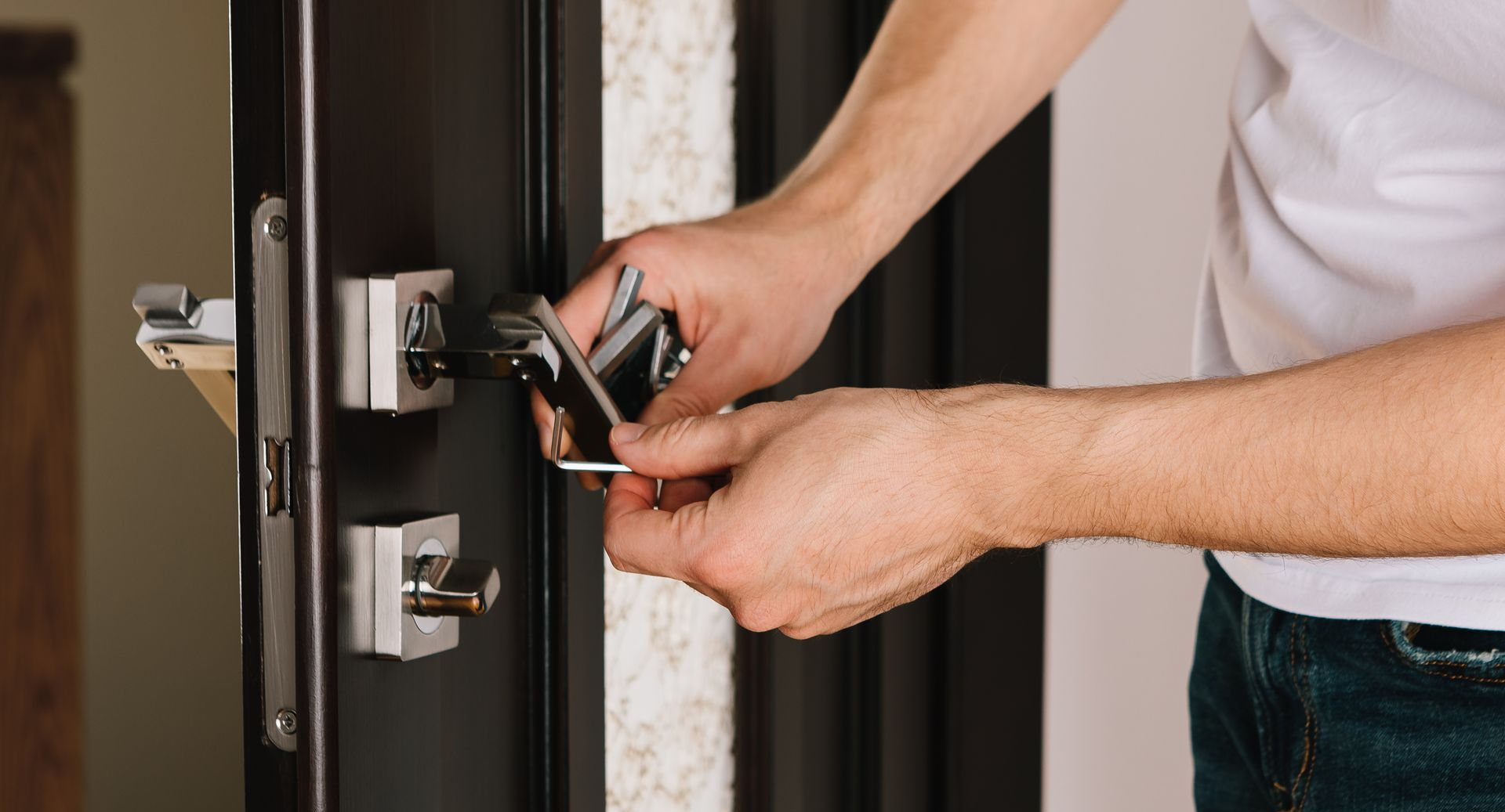 Personne utilisant une clé Allen pour régler une serrure de porte sur un cadre de porte.