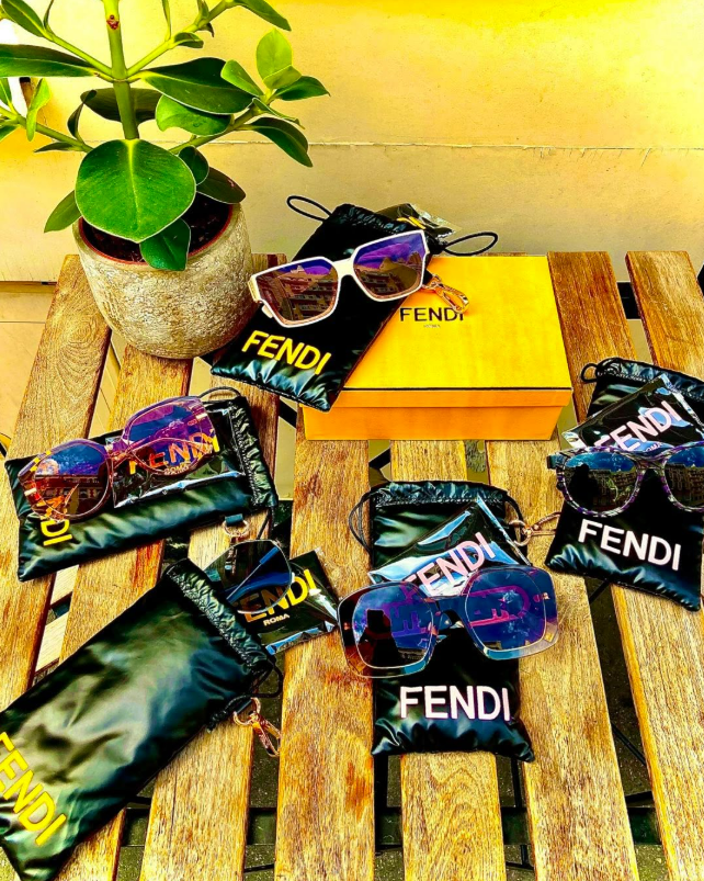 Plusieurs paires de lunettes de soleil Fendi posées sur une table basse en bois