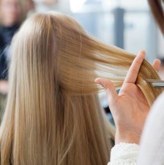 Une coiffeuse effectue un diagnostic capillaire sur une jeune femme blonde
