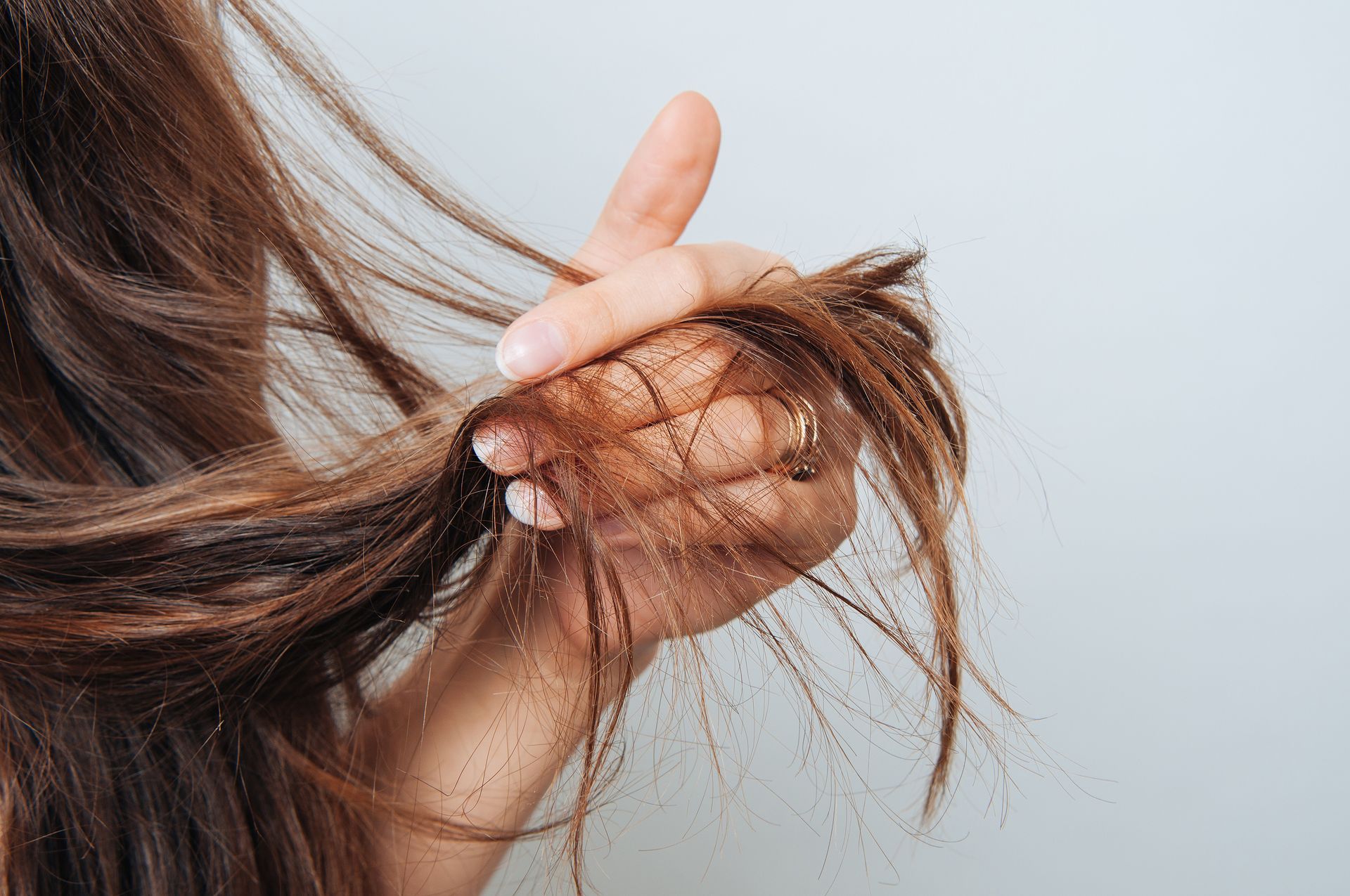 Une femme montre les pointes de ses cheveux