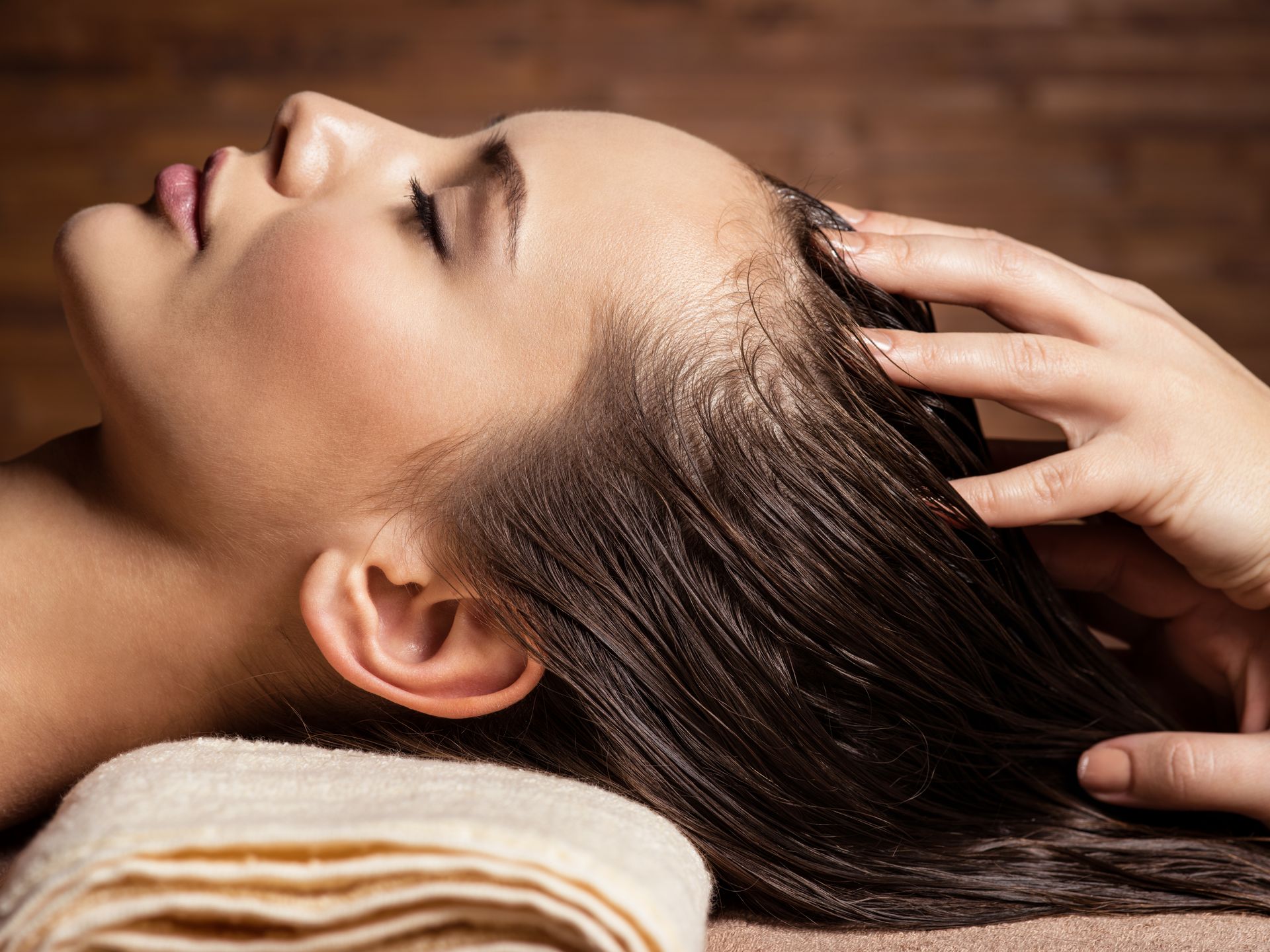 Femme allongée qui se fait masser la tête