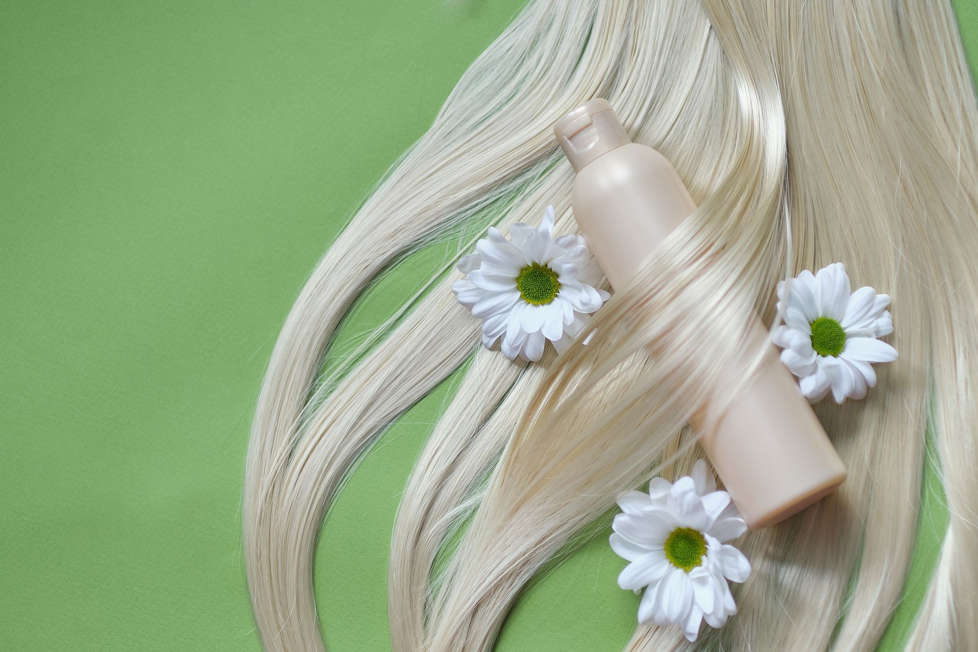 Cheveux blonds avec des marguerites et une bouteille de shampooing beige