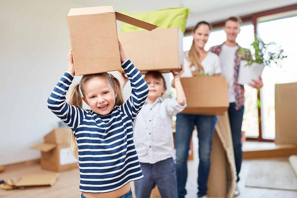 Eine Familie trägt Kisten in einem neuen Haus .