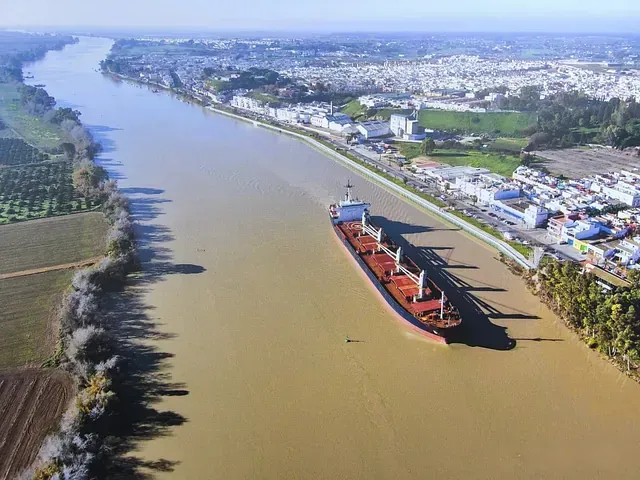 Un gran barco está atracado frente a una gran refinería de petróleo.