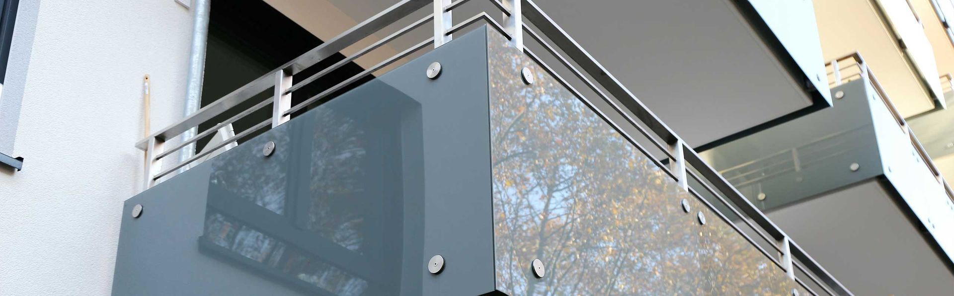 Moderner Balkon mit getönten Glaspaneelen und Edelstahlgeländer.