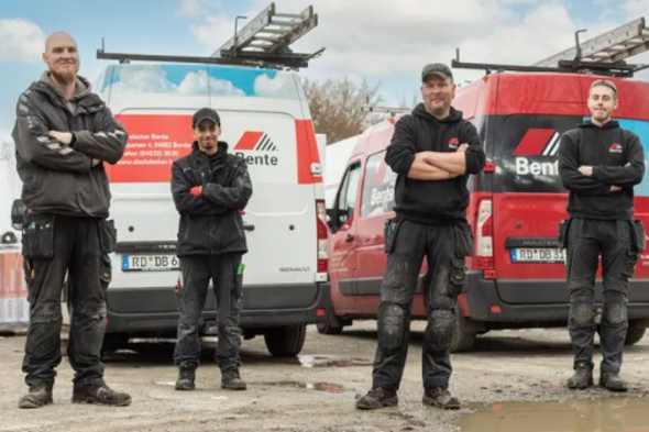 Vier Mitarbeiter von Dachdecker Bente stehen mit vor zwei roten und einem weißen Firmenfahrzeug mit Bente-Logo, im Hintergrund Dachleitern auf den Fahrzeugdächern.