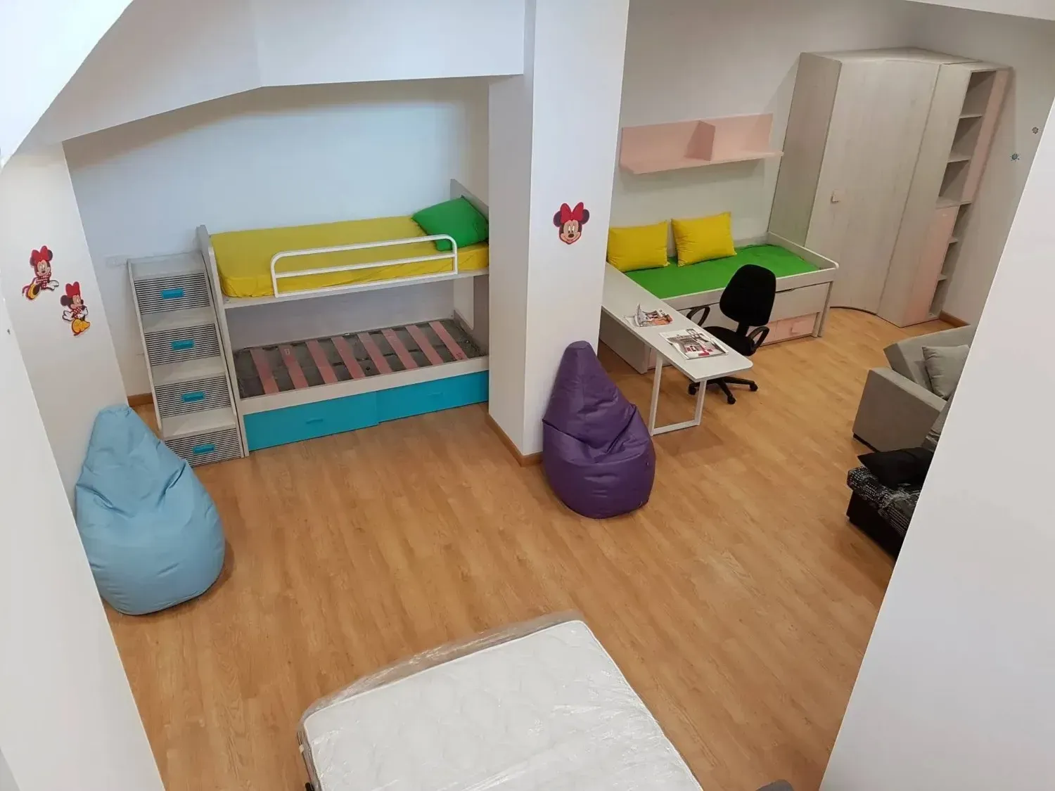 Una habitación infantil con una litera, una cama individual.