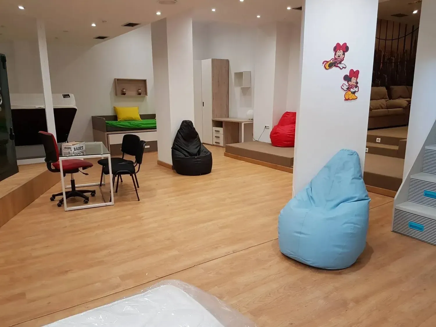 Una sala de exposición de una tienda de muebles muy iluminada, con sillones tipo puf.