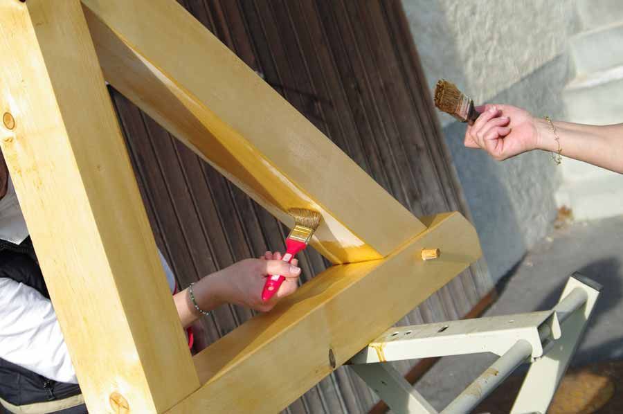 Deux personnes en train de protéger une charpente avec du produit