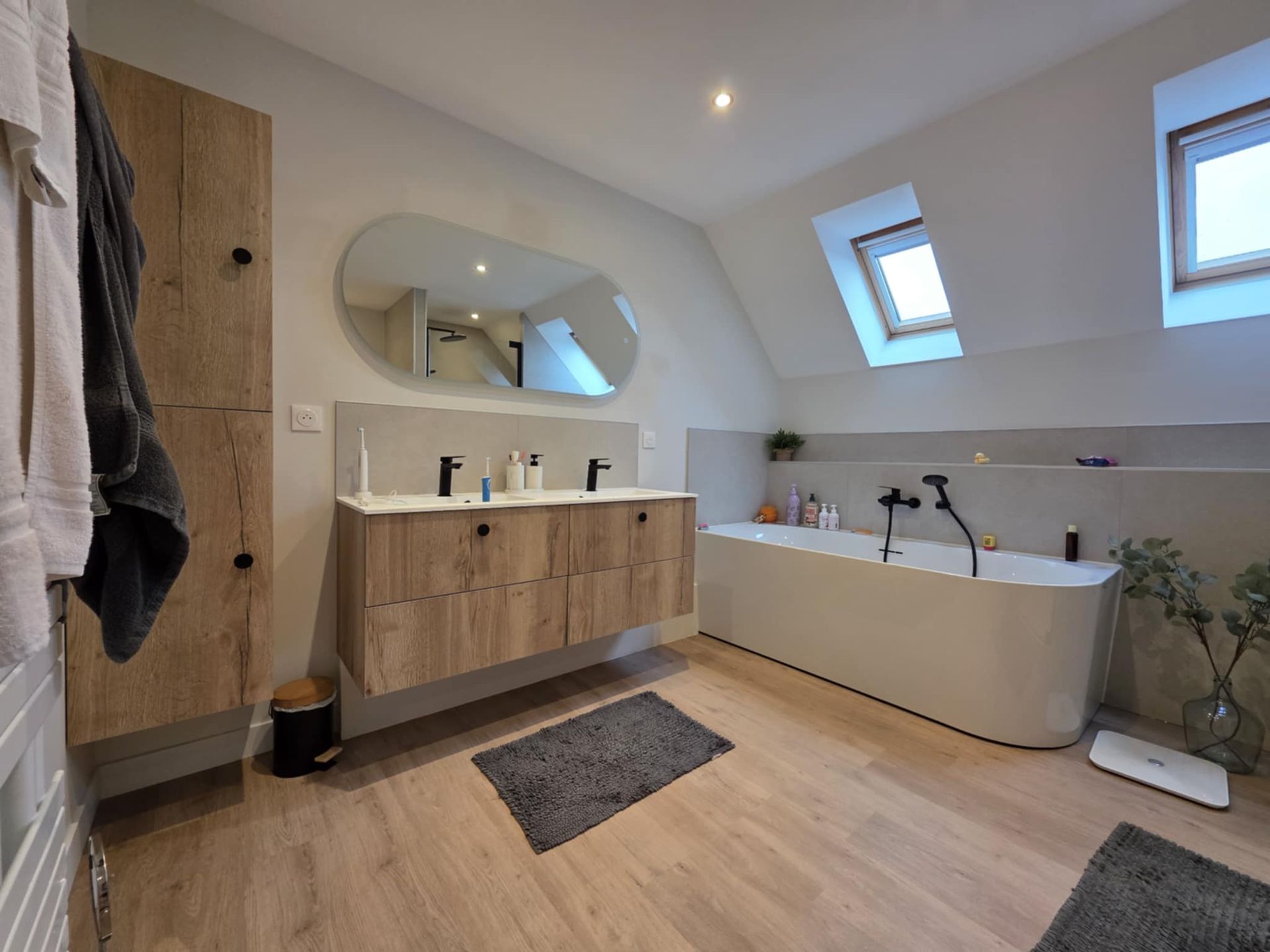 travail installation d'une baignoire blanche dans une salle de bain moderne.