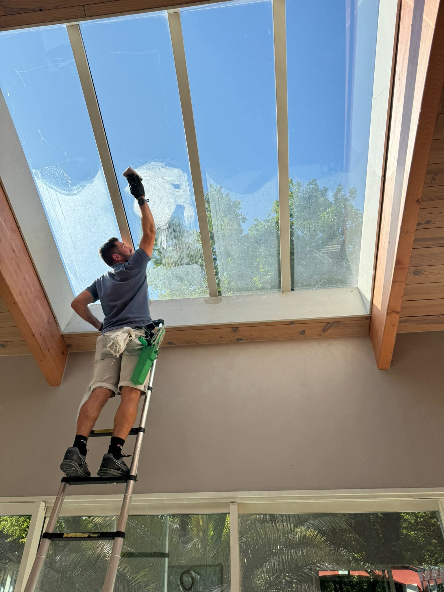 Lavage d'une verrière de toit sur échelle