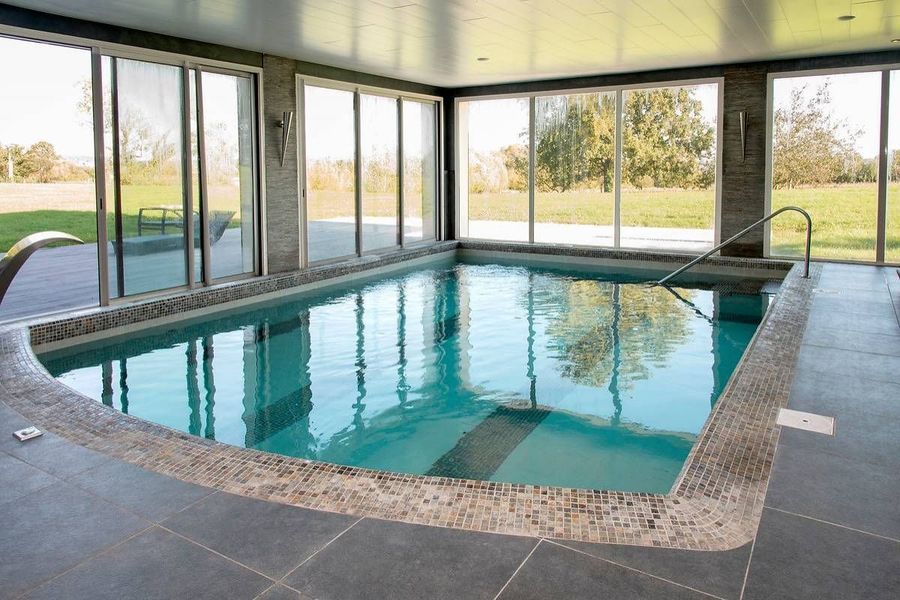 Piscine intérieure avec des baies vitrées