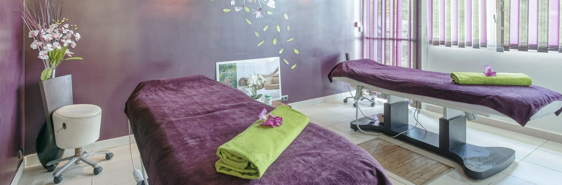 Pièce d'un institut de beauté avec deux tables couvertes de serviettes violettes et vertes