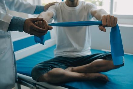 Un médico está ayudando a un paciente con una banda de resistencia.