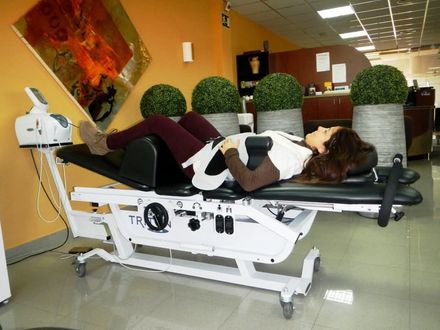 Una mujer está colocando cinta kinesiológica en el brazo de un hombre.
