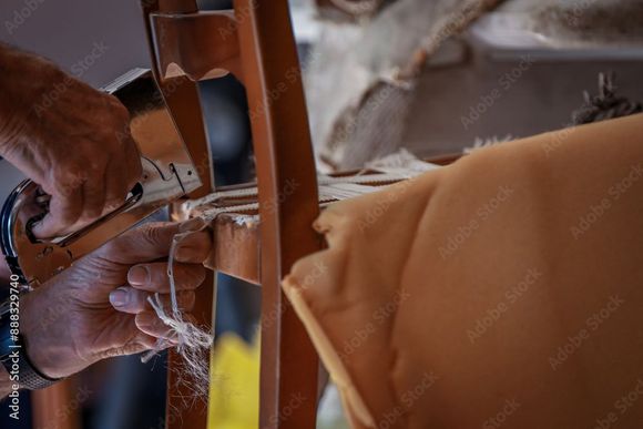 Une personne répare une chaise avec une agrafeuse.