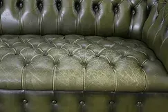 Un gros plan d'un canapé en cuir vert avec des boutons.