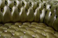 Un gros plan d'un canapé en cuir vert avec des boutons.
