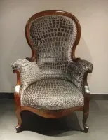 Une chaise avec un imprimé crocodile est posée sur le sol.