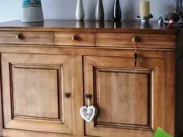 Une commode en bois avec un cœur accroché à la porte.
