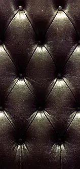 Un gros plan d'un canapé en cuir noir avec des boutons dessus.