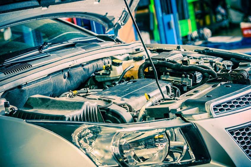 El capó de un coche está abierto y el motor es visible.