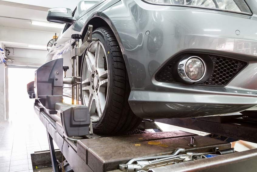 Se está ajustando un coche en un elevador en un garaje.