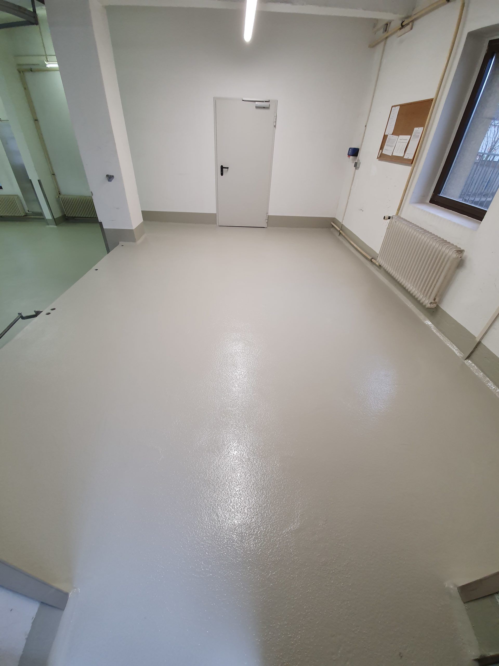 ein Raum mit einem weißen Boden und einer weißen Tür .