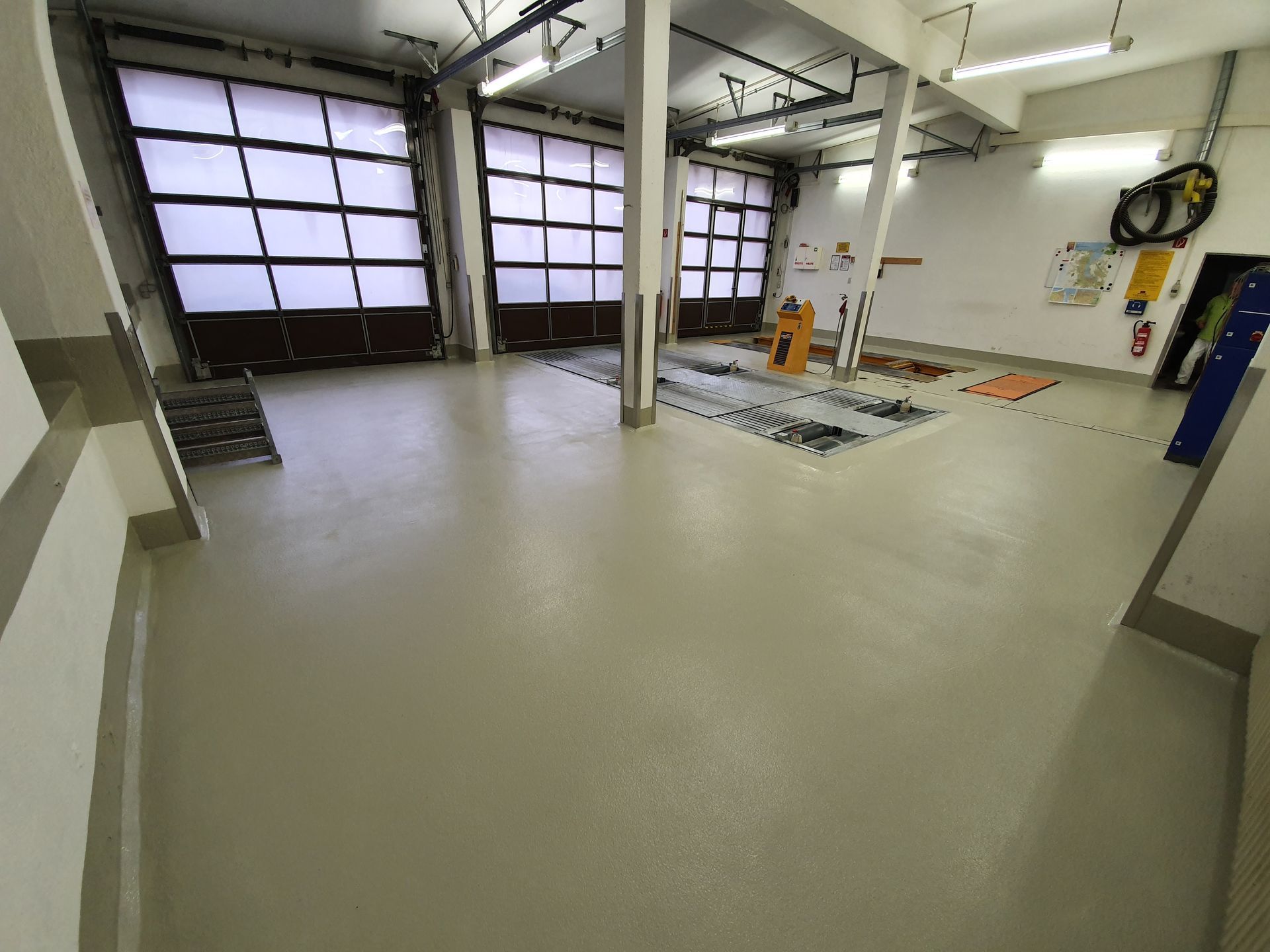 ein großer Raum mit einer Garagentür und einer Treppe .