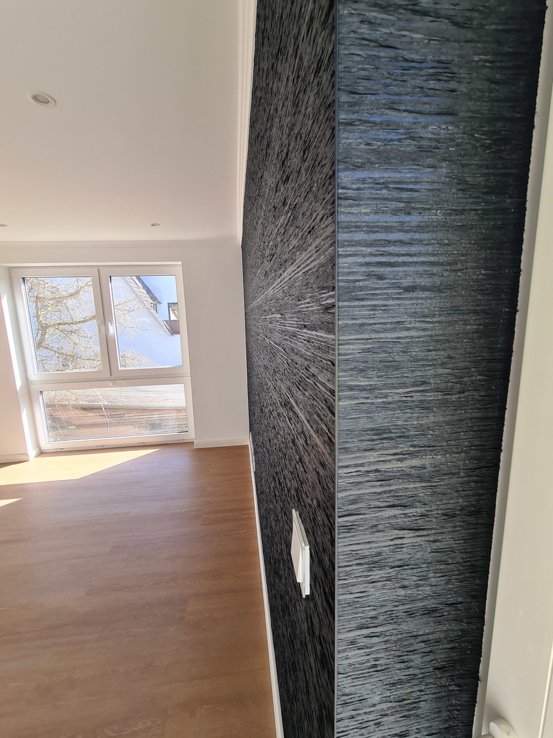 ein leerer Raum mit einer Steinmauer und einem Fenster. Zimmer  Malerarbeiten Rostock