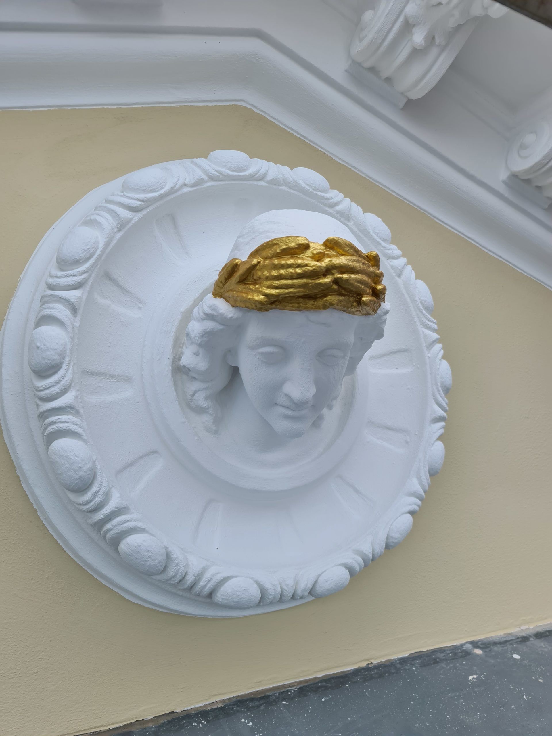 eine weiße Statue einer Frau mit goldenen Haaren