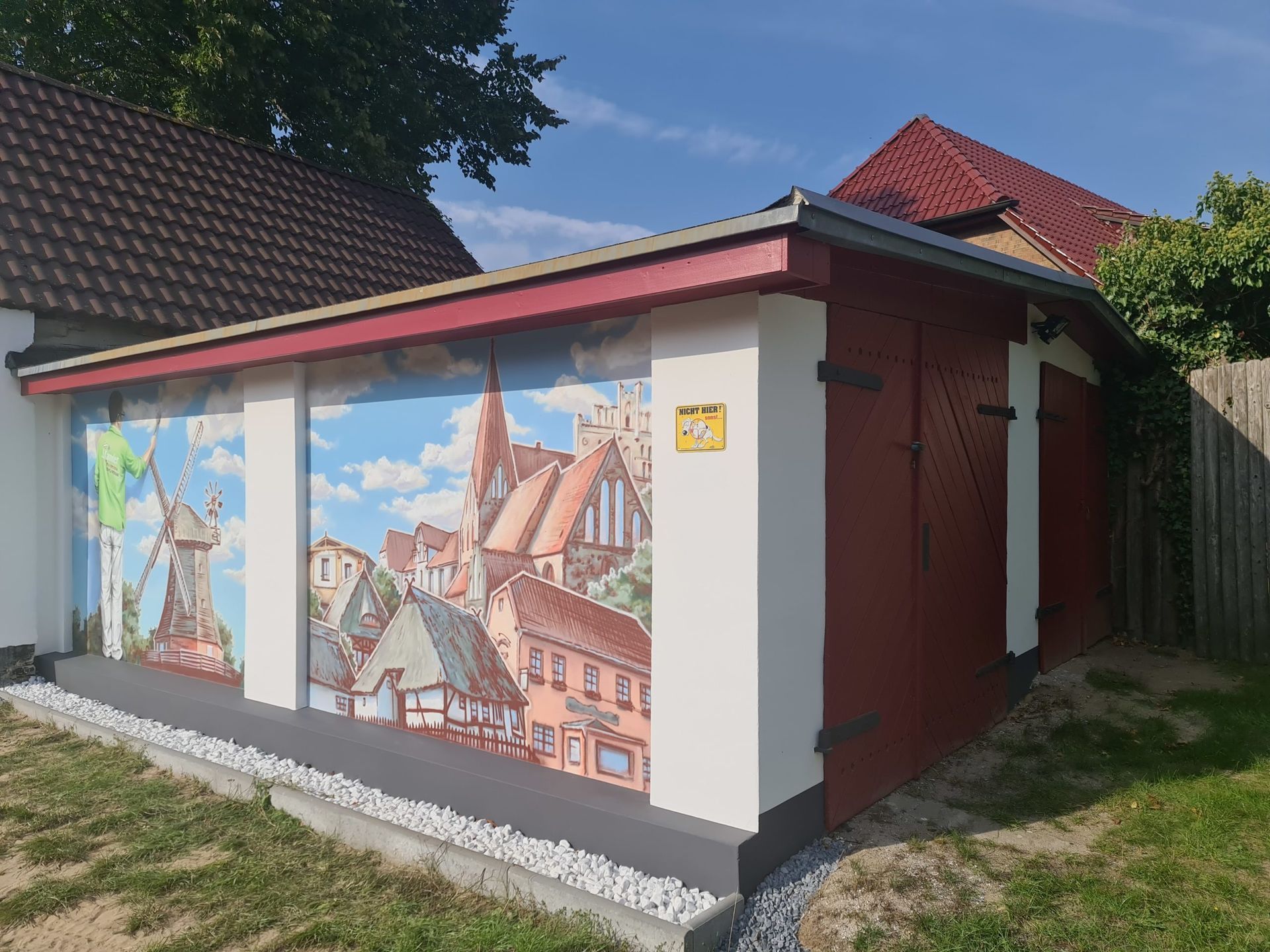 ein rot-weißes Gebäude mit einem Gemälde an der Seite .