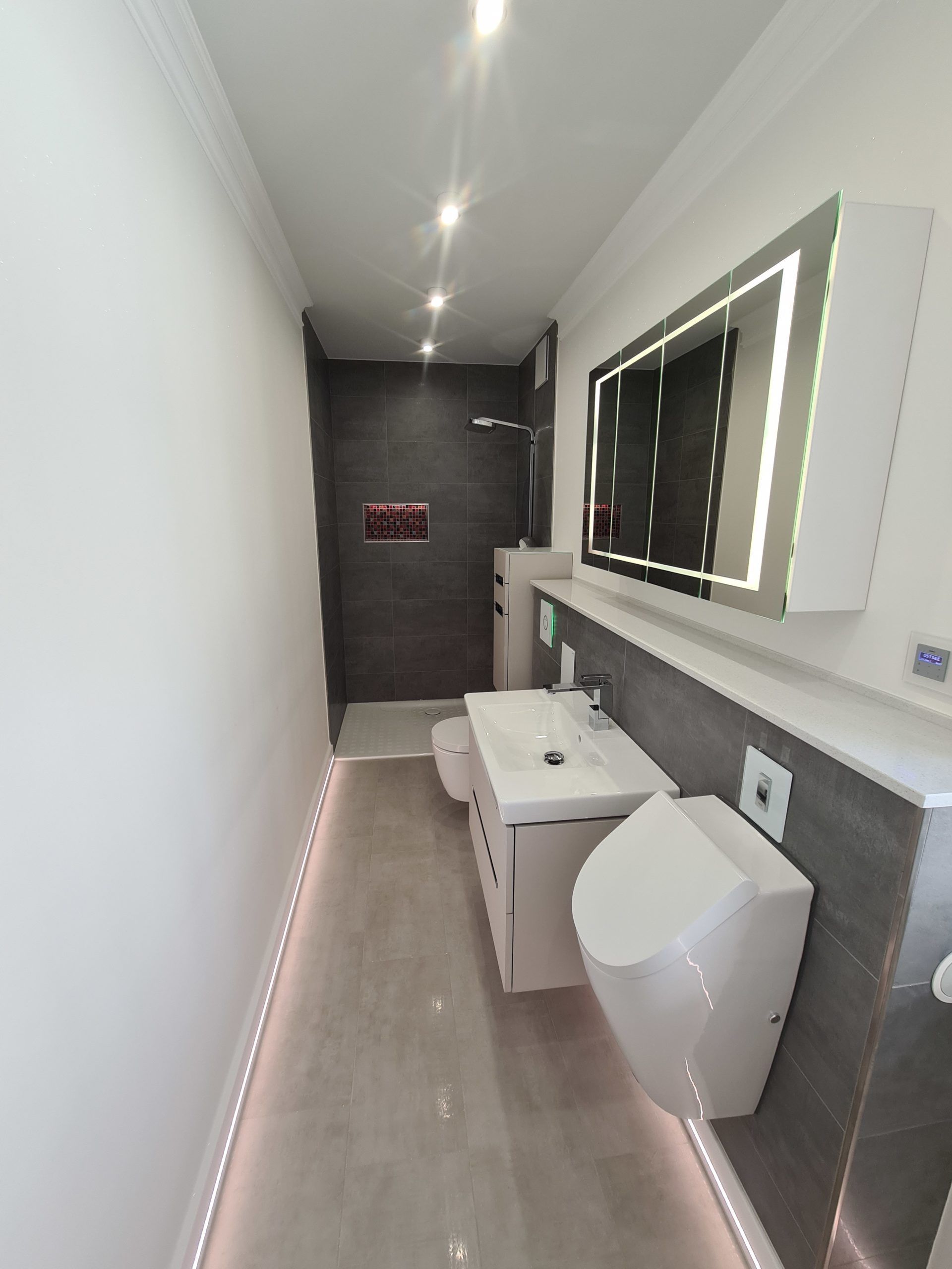 ein Badezimmer in Rostock mit Waschbecken , WC und Spiegel . Maler, Malerarbeiten