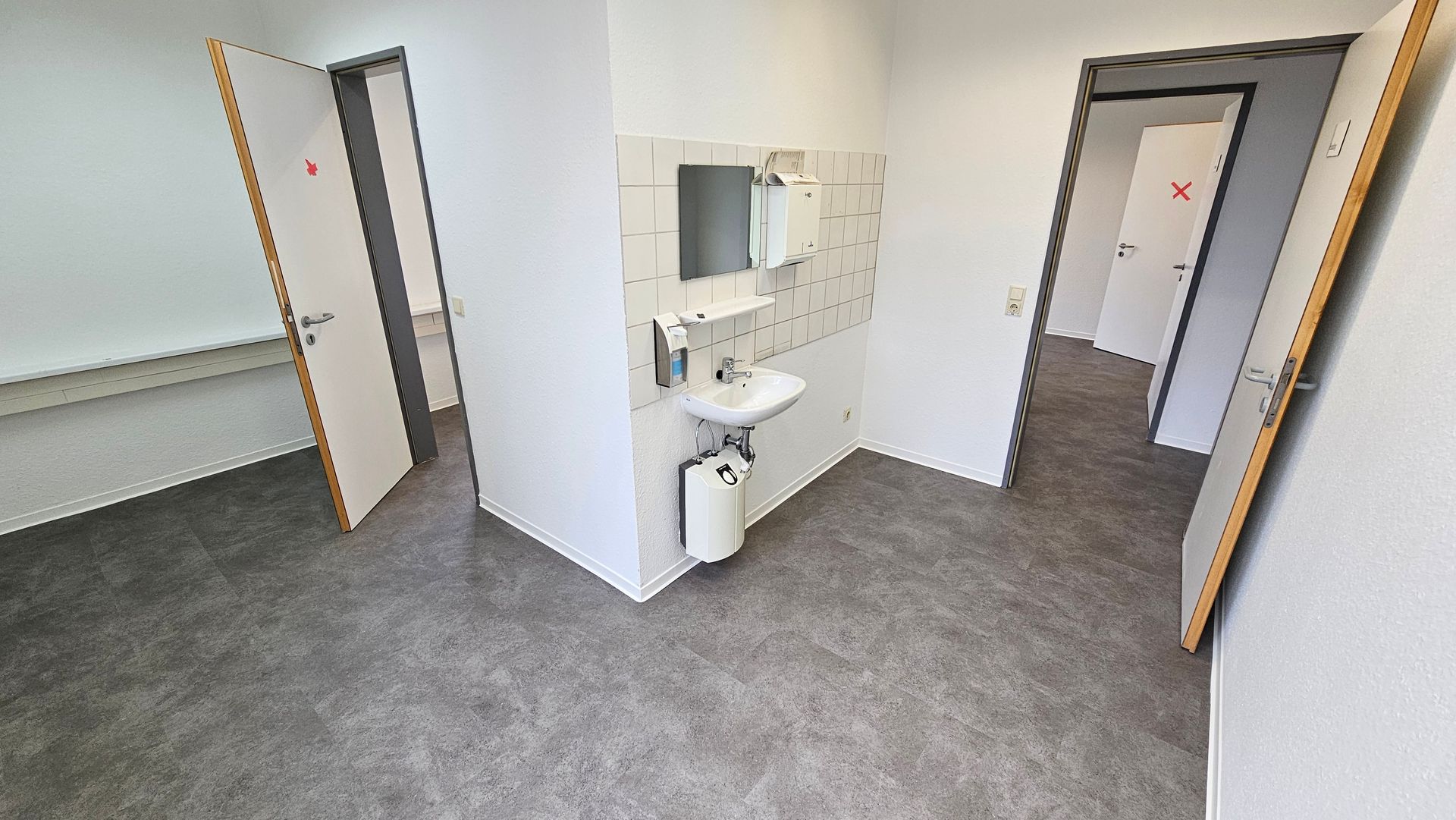 ein Raum mit Waschbecken , Spiegel und Türen .