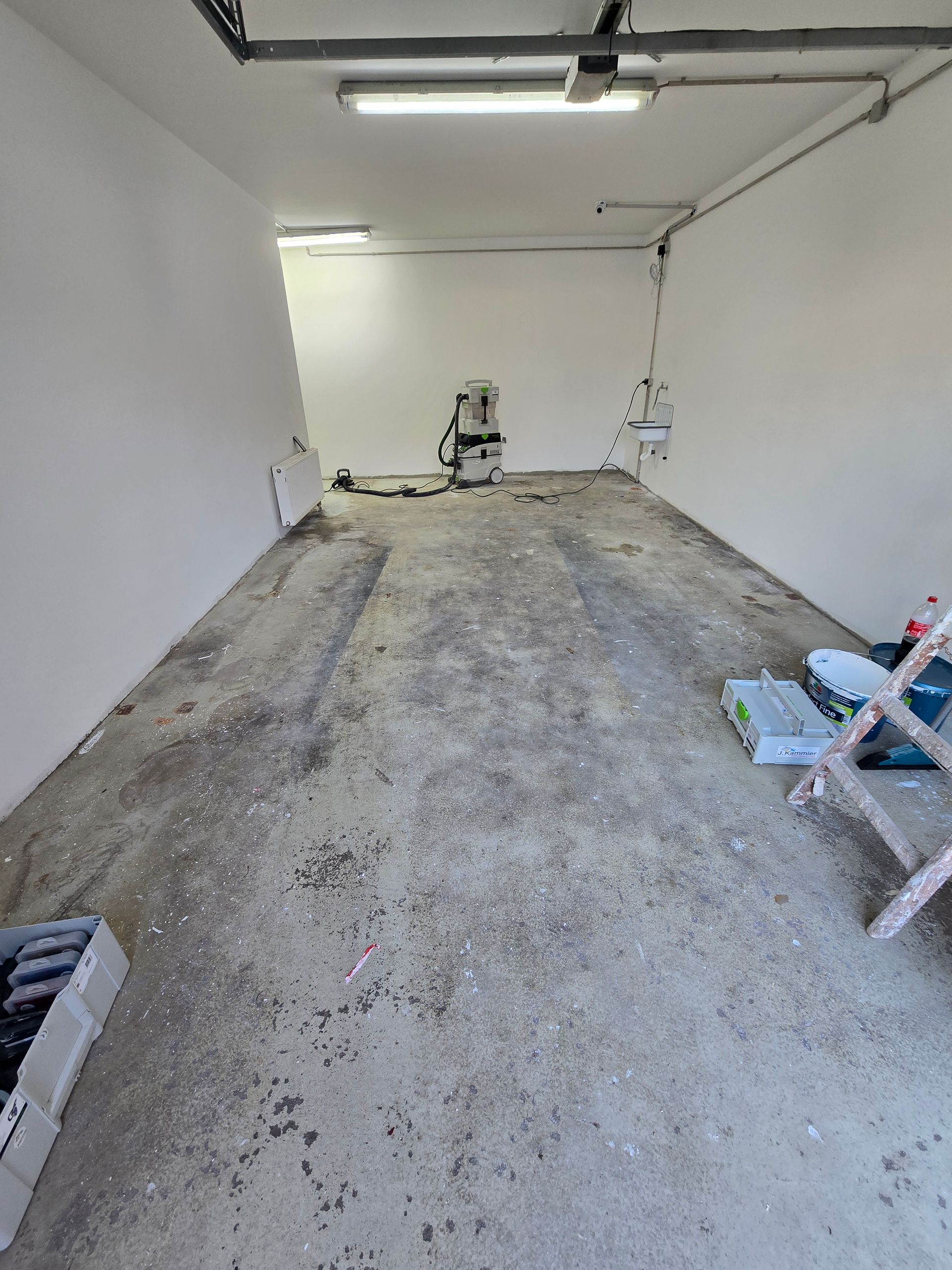 Garage alt mit weißen Wänden und Staubsauger.