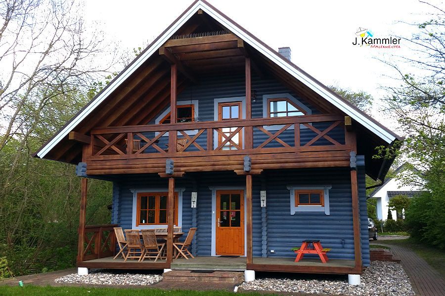 ein blaues Haus mit einem Holzdeck und einer orangefarbenen Tür