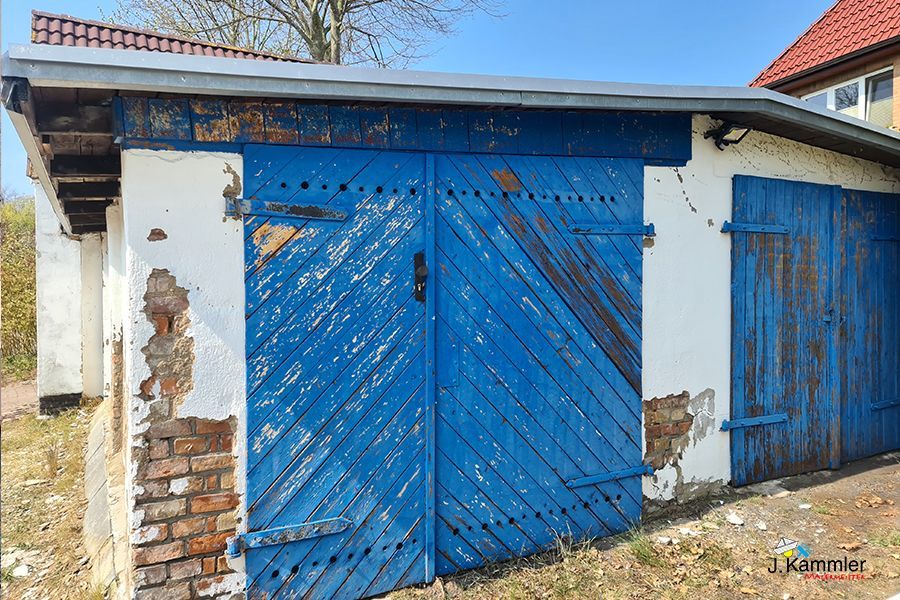 eine blaue Garage in Rostock mit einem weißen Gebäude dahinter .