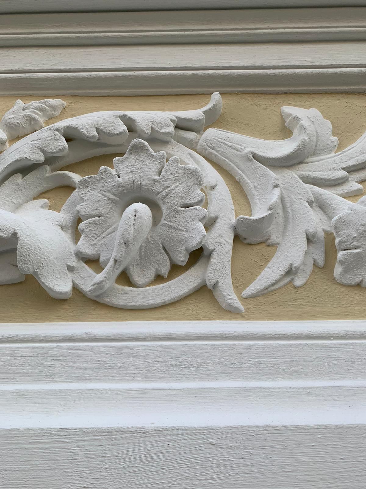 eine Nahaufnahme einer Blumenverzierung an einer Wand .