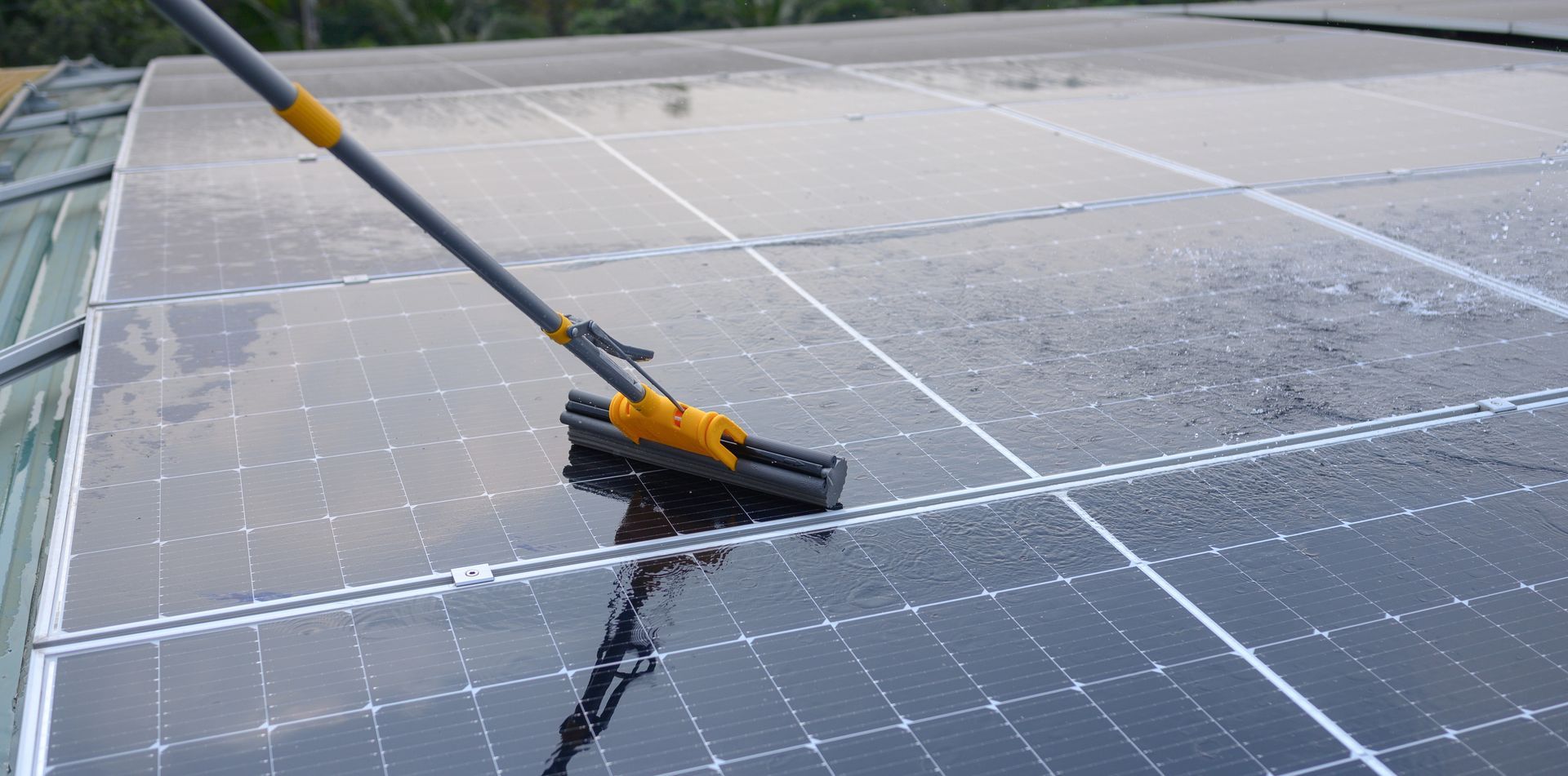 Se limpia el techo de paneles solares con un cepillo de mango largo y un chorro de agua.