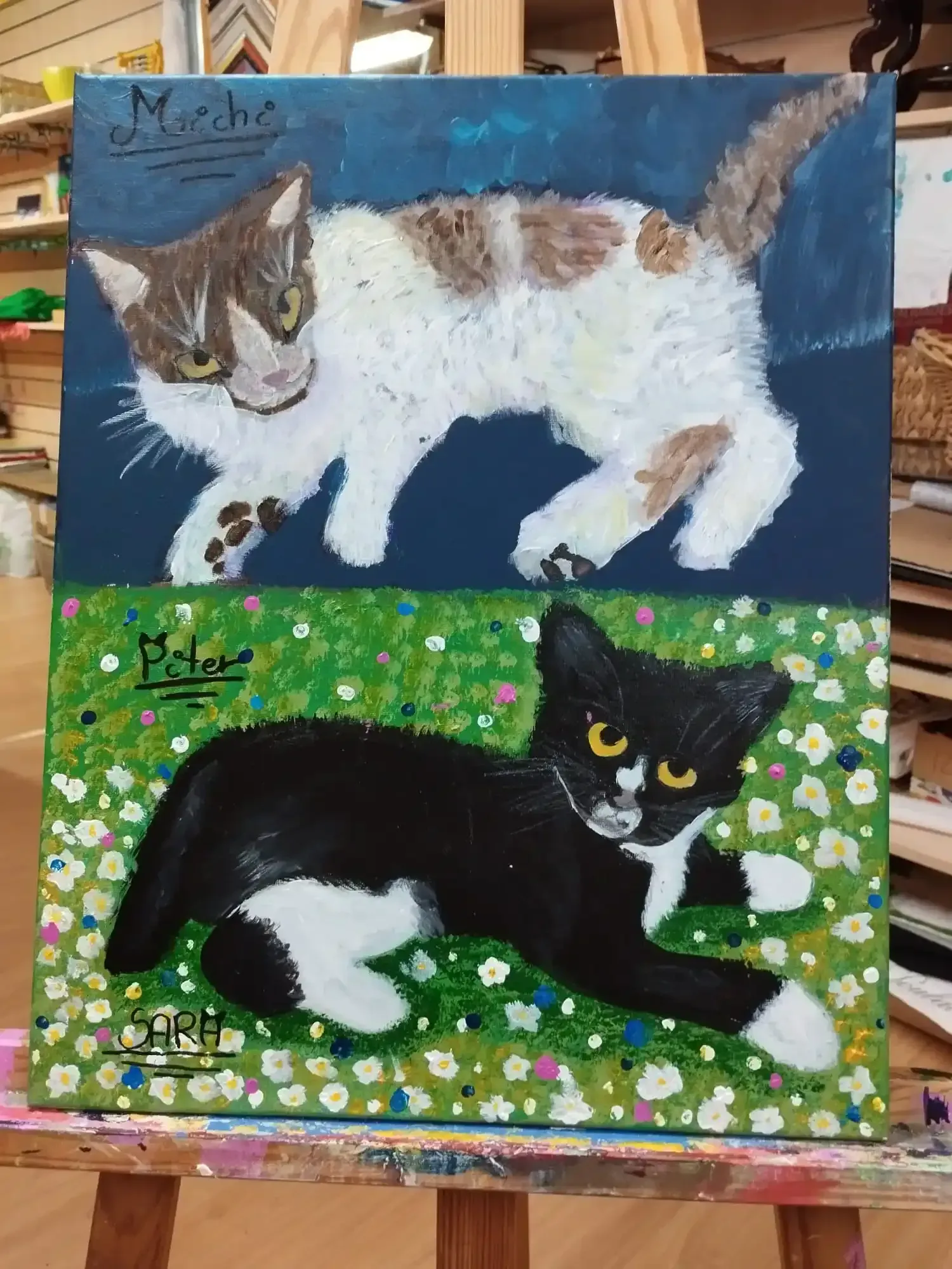 Dos cuadros de gatos: uno blanco, marrón y gris sobre fondo azul; otro en blanco y negro sobre césped verde.